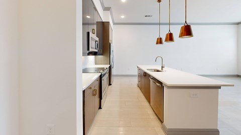 A modern kitchen with a white countertop and wooden cabinets.